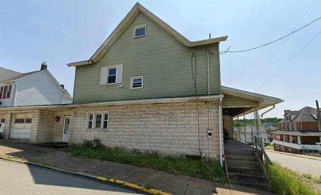 a view of a house with wooden fence