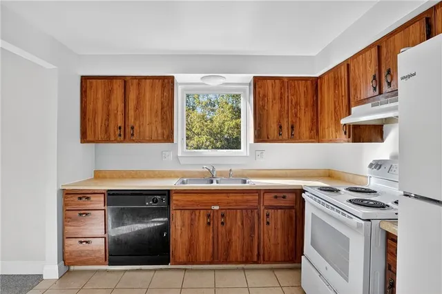 a kitchen with a sink stove top oven and cabinets