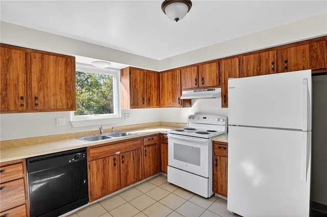a kitchen with a sink a stove a refrigerator and cabinets