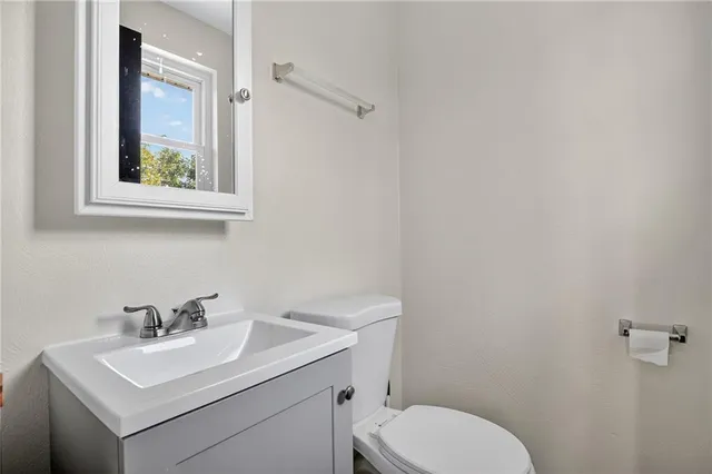 a bathroom with a toilet a sink and mirror