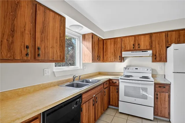 a kitchen with a stove sink and cabinets