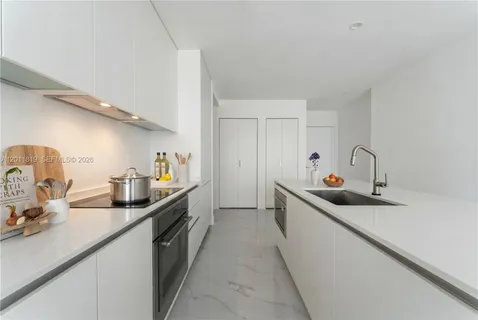 a kitchen with a sink a stove and cabinets
