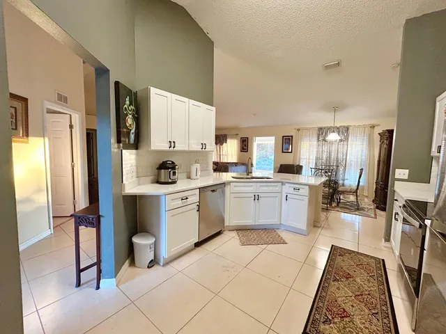 a kitchen with a refrigerator sink cabinets and wooden floor