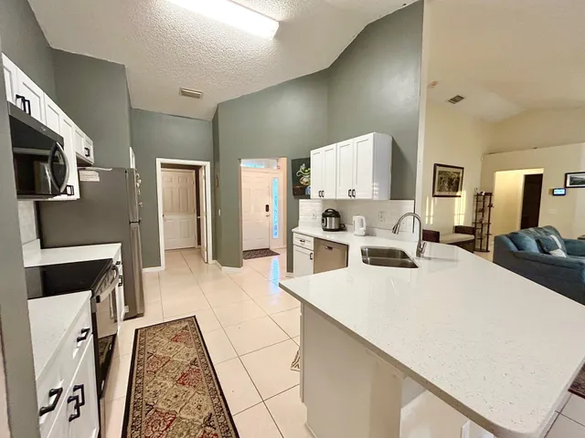 a large white kitchen with stainless steel appliances