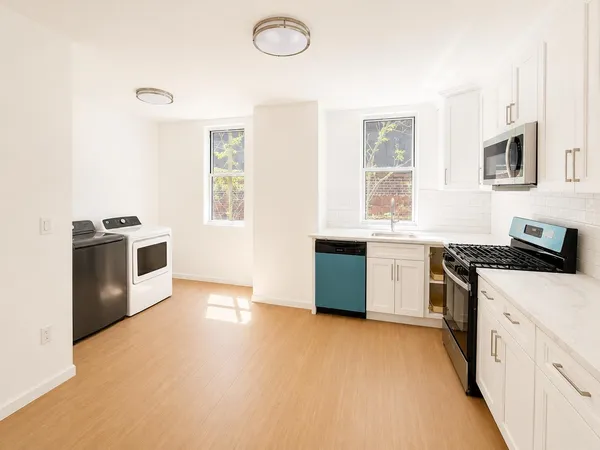 a kitchen with stainless steel appliances a stove a sink a microwave a counter top and cabinets
