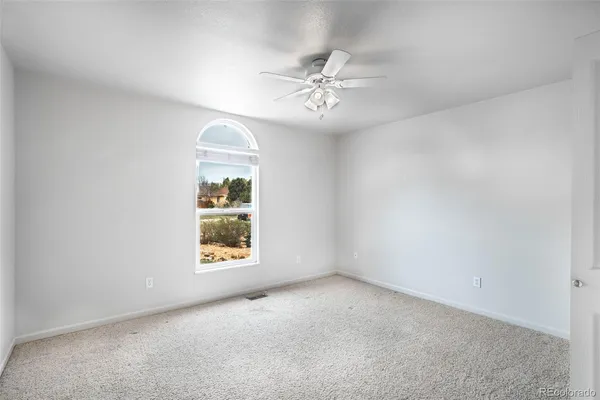 a view of an empty room with a ceiling fan