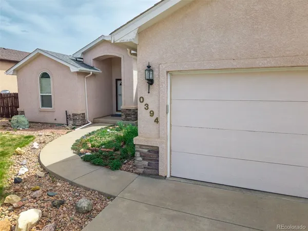 a view of a house with a small yard and garage
