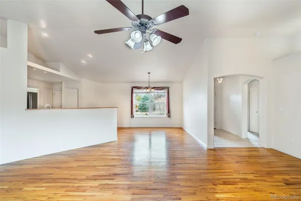 a view of an empty room with window and wooden floor
