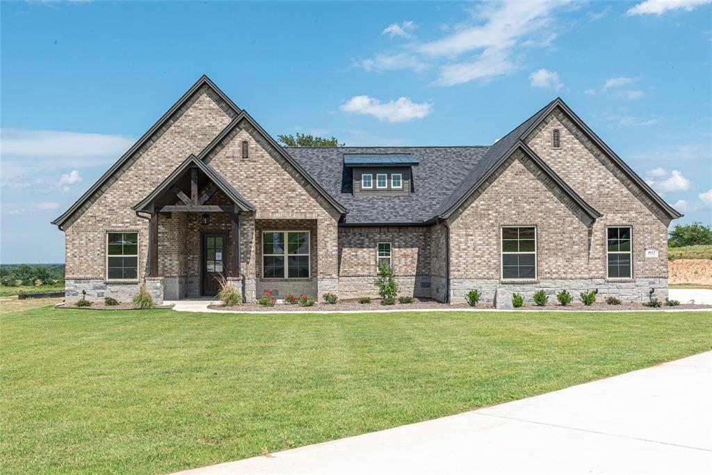 a front view of house with a garden and trees