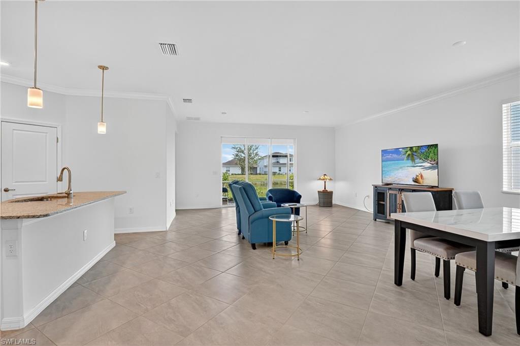 2126 Hamlin Street Naples, FL 34120 - Photo 2 of 38 a living room with furniture a dining table and chairs