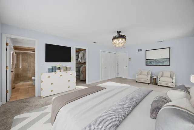 a bathroom with a granite countertop double vanity sink a toilet a mirror and shower