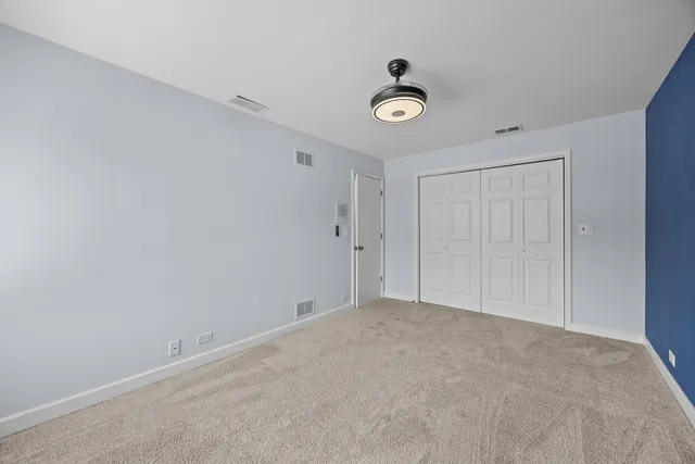 a view of an empty room with wooden floor and stairs