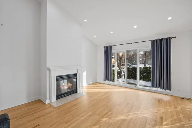 a view of an empty room with a fireplace and a window
