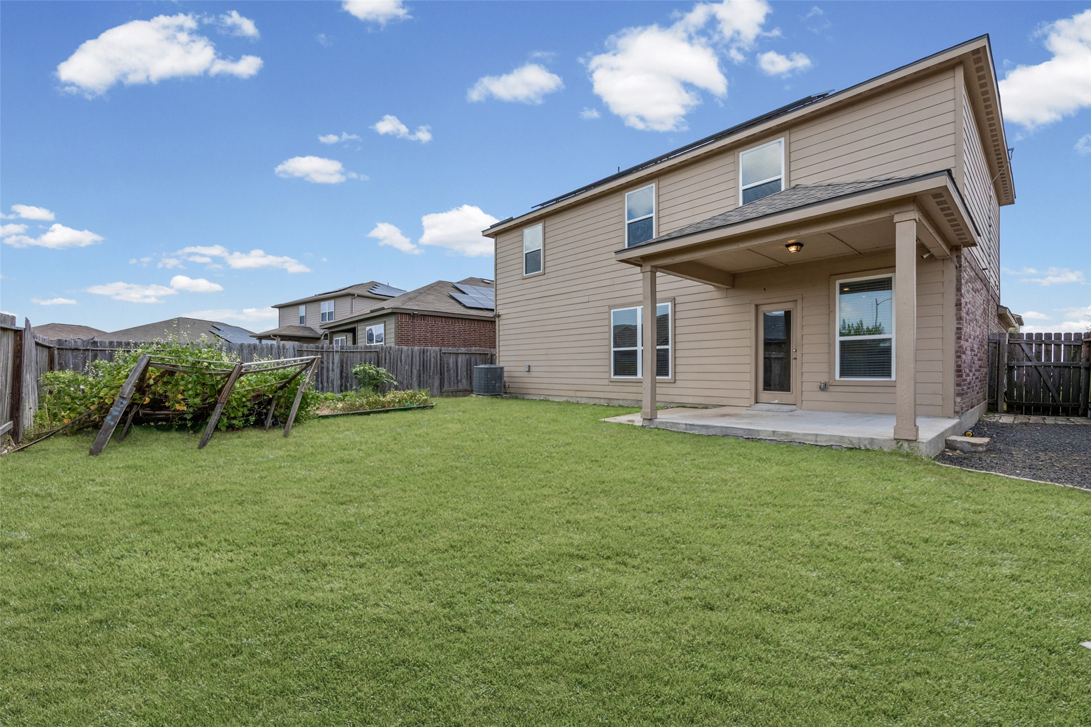 19812 Hubert R Humphrey Road Manor, TX 78653 - Photo 23 of 29 A spacious backyard with a covered patio offers ample room for outdoor activities.