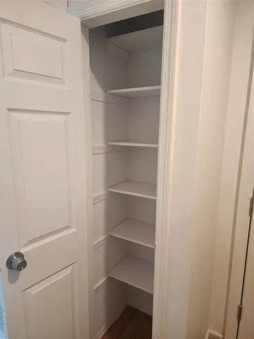 a view of walk in closet with empty racks