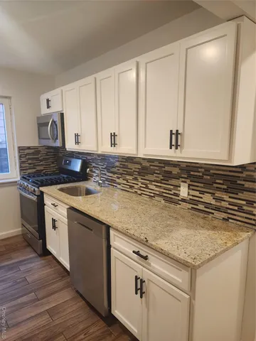 a kitchen with granite countertop white cabinets and white appliances