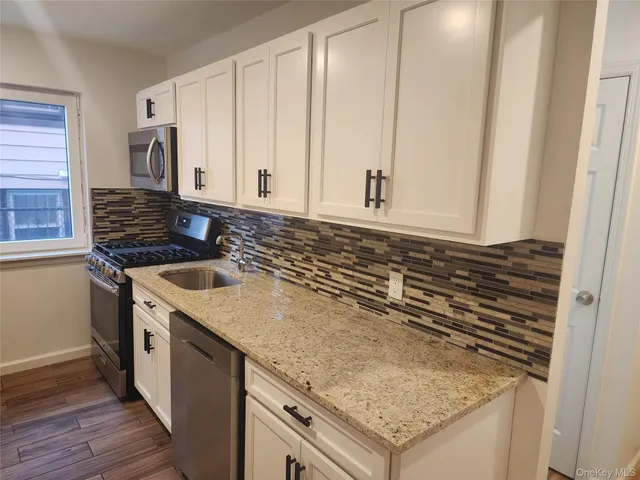 a kitchen with granite countertop a sink and a stove