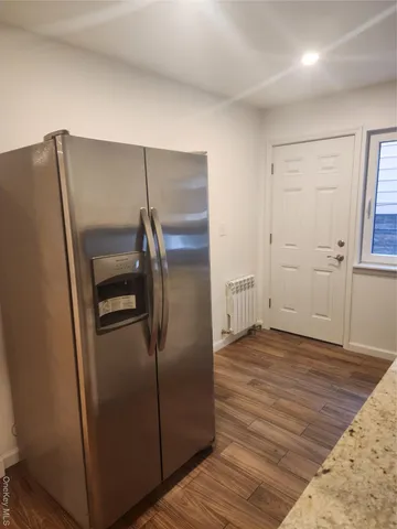 a view of a refrigerator in kitchen and a wooden floor