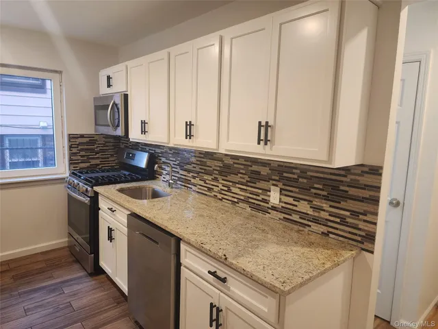 a kitchen with granite countertop a sink and a stove