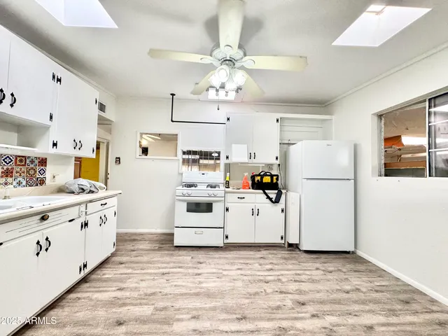 a kitchen with cabinets a refrigerator and a stove top oven