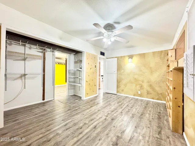 a view of a big room with wooden floor and a bathroom