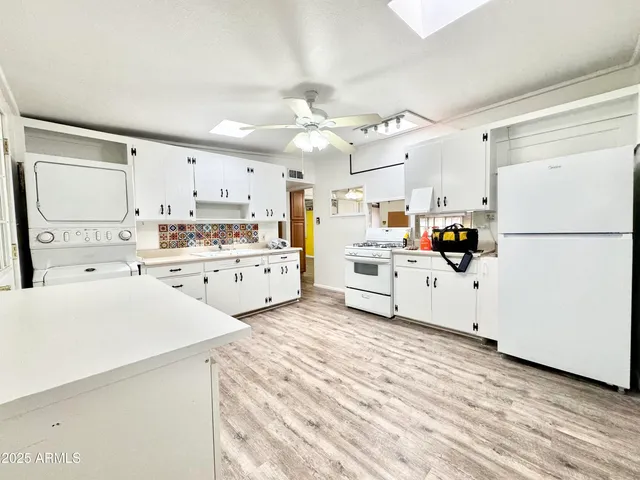 a kitchen with cabinets a sink and white appliances