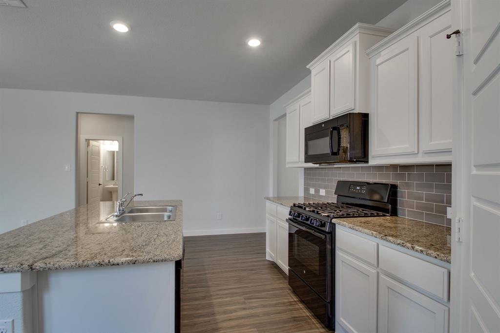 7612 Spring Drive Watauga, TX 76148 - Photo 13 of 40 a kitchen with granite countertop a sink and steel appliances
