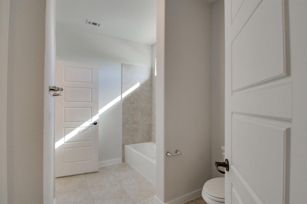 7612 Spring Drive Watauga, TX 76148 - Photo 24 of 40 a bathroom with a toilet and a shower