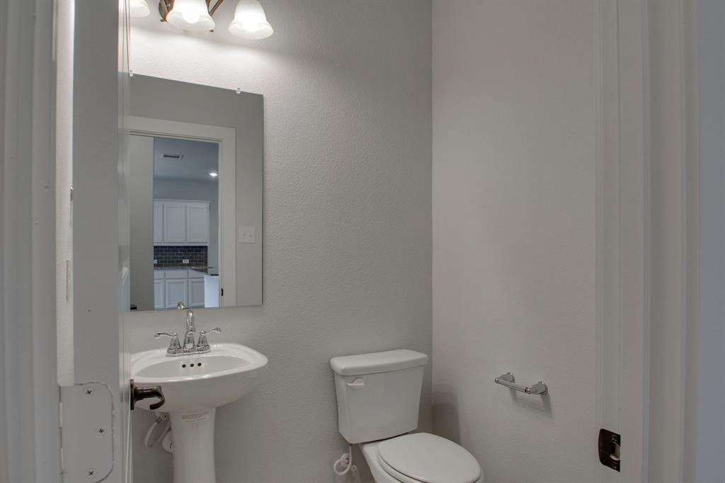 7612 Spring Drive Watauga, TX 76148 - Photo 34 of 40 a bathroom with a toilet a sink and mirror