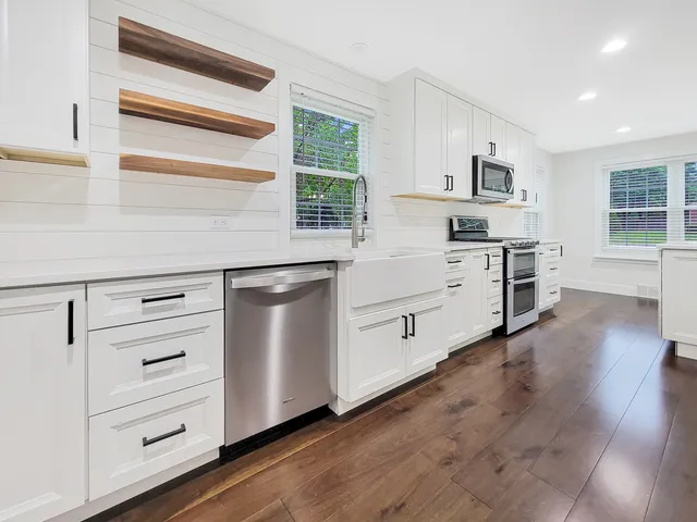 a kitchen with white cabinets and sink