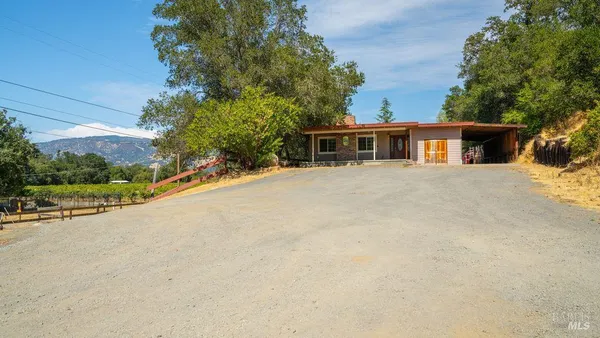a front view of house with yard and trees around