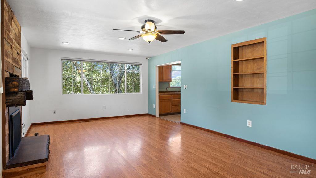 40 El Rancho Drive Cloverdale, CA 95425 - Photo 11 of 44 an empty room with wooden floor chandelier fan and windows