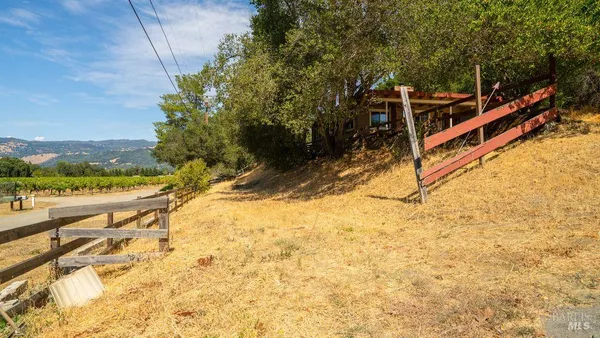 a view of a yard with wooden fence