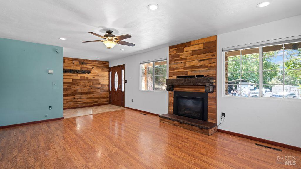 40 El Rancho Drive Cloverdale, CA 95425 - Photo 9 of 44 an empty room with windows fireplace and a ceiling fan