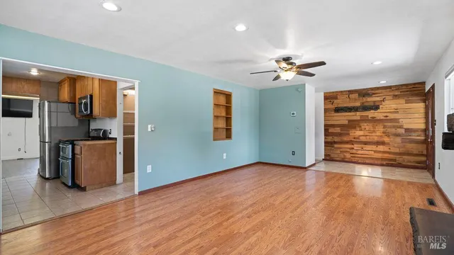 a view of an empty room with a window and wooden floor