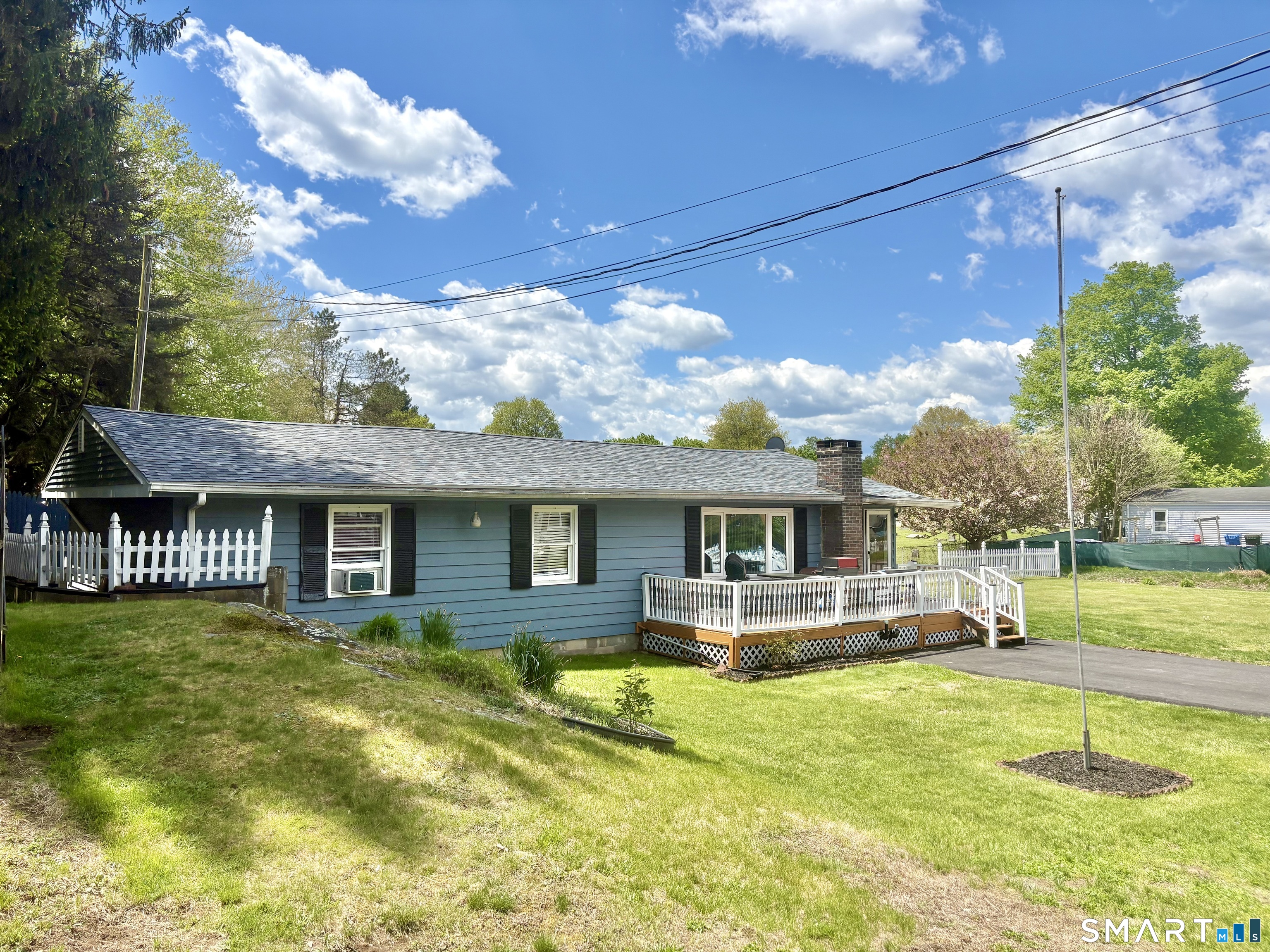 a front view of house with yard and trees in the background