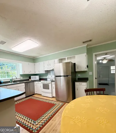 a kitchen with a refrigerator a stove top oven a sink and cabinets