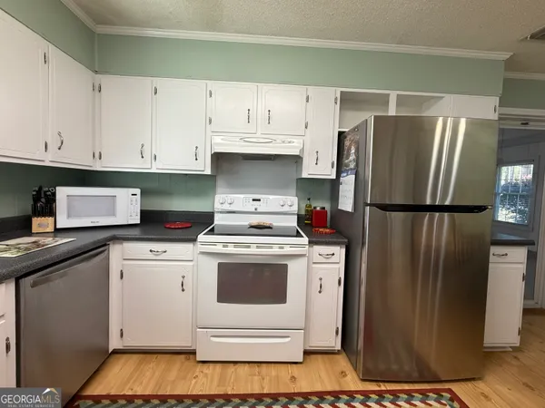 a kitchen with a refrigerator and a stove top oven