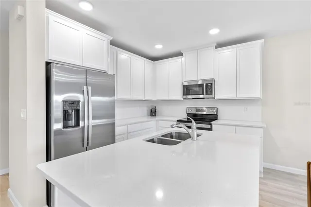 a kitchen with granite countertop a refrigerator sink and microwave