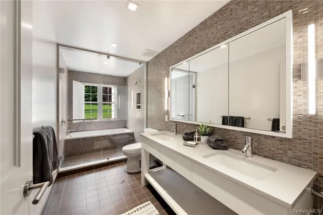 a bathroom with double vanity and a bathtub