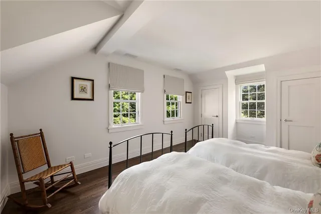 a bedroom with a bed a table and wooden floor