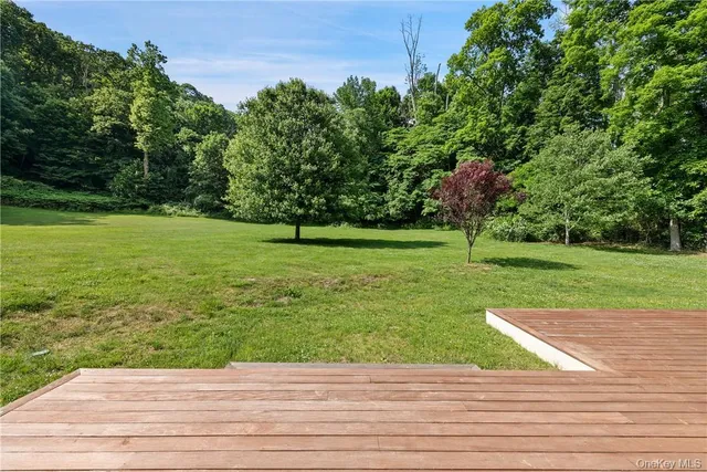a front view of house with yard and trees in the background