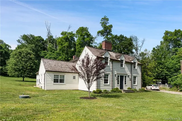 a view of a house with a big yard and large trees