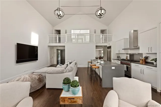 a living room with furniture a flat screen tv and kitchen view