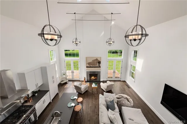 a living room with couches a fireplace and a flat screen tv