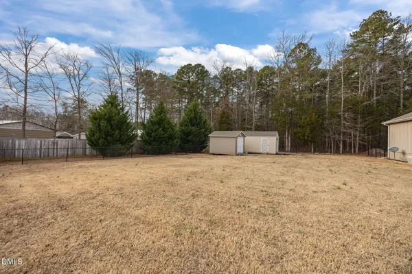 a front view of a house with a yard and tree s