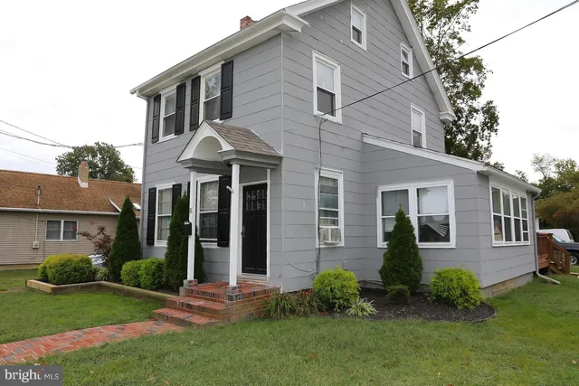 a front view of a house with a yard and outdoor seating
