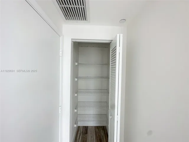a view of walk in closet with empty racks