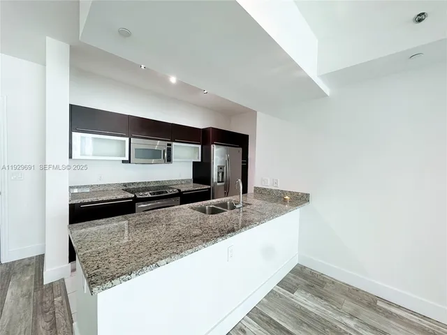a kitchen with granite countertop a sink and a stove