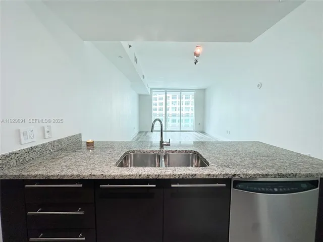 a kitchen with granite countertop a sink and cabinets